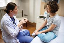 Doctor talking with teen girl.